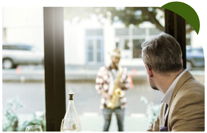 Mature man - listening to musician with the help of a hearing aid